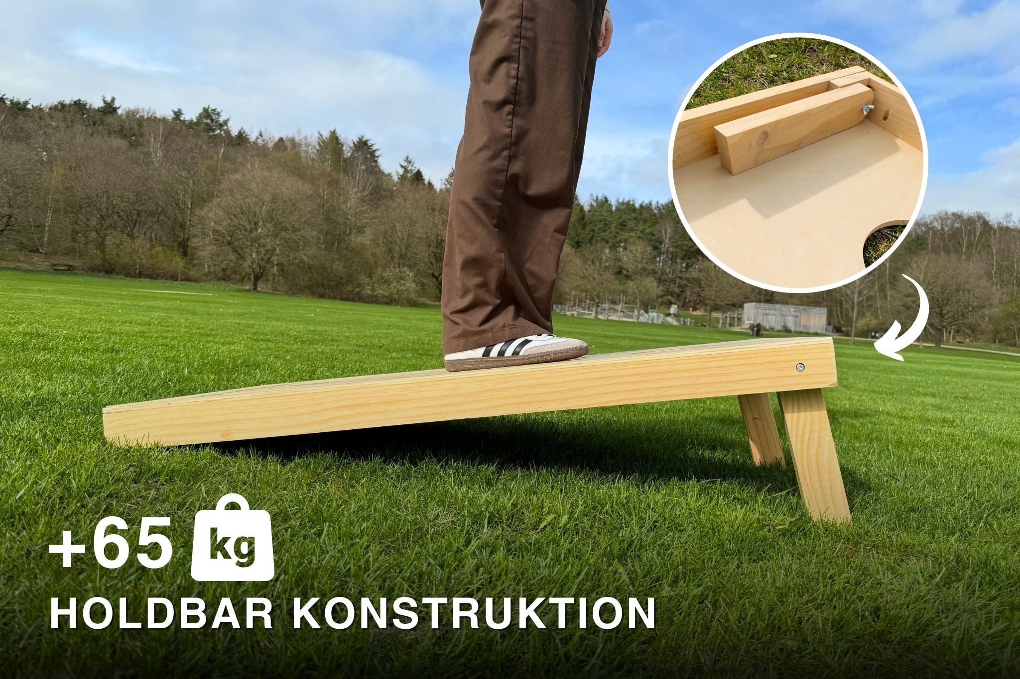 Person står ovenpå et cornholespil i de officielle mål 120x60 fra cornhole.dk for at teste holdbarheden og personen vejer 65 kg, hvilket viser at spillet er ekstremt robust.